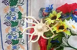 A flower-shaped cookie among plastic flowers