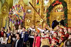 People in traditional costumes in a church, some playing musical instruments