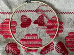 A towel being embroided with red string