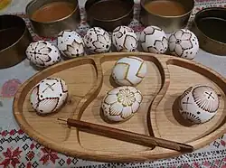 Eggs partly covered in wax, ready to be placed in coloring