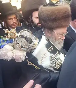 Rabbi From Stitchin wearing his grandfather's kolpik when bringing a Torah scroll into his Beit Midrash in Borough Park