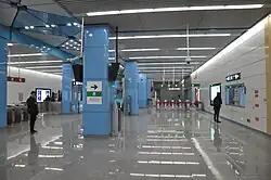 Station concourse with faregates in the background