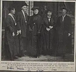 A group photo of five women in silk gowns used in graduation ceremonies.