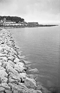 This jetty is the western boundary of Mission Point. Looking east, this 1969 view shows the Mackinac College campus, with the Peter Howard Memorial Library and Clark Center. The eastern boundary of Mission Point, Robinson’s Folly, is in the background.