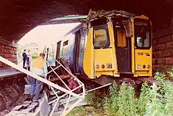 An image of the 1987 train crash, with damage to its roof and debris including the buffer stop in frame