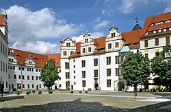 A building with white walls and a red roof