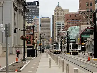 Trains on a city street surrounded by tall buildings