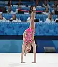 Holding connected clubs with one foot during a walkover (Yulia Vodopyanova)