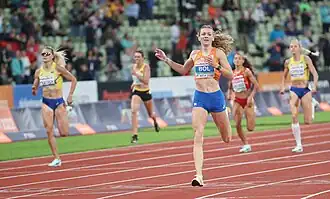 Photo of Viktoriya Tkachuk, Carolina Krafzik, Femke Bol, Sara Gallego, and Anna Ryzhykova on the track with spectators in the background