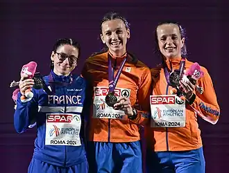 Photo of Louise Maraval, Femke Bol, and Cathelijn Peeters wearing track suits and holding their medals and stuffed mascots