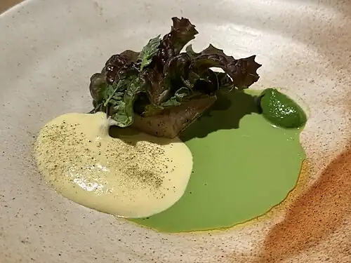Calamari sausage under a lettuce leaf, with sabayon and emulsion