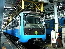 Blue mass-transit train pulling into a station