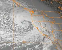 Satellite image of the Western United States, Western Canada, and the Pacific Ocean, with the states of the US shown in orange lines. The November 13-15, 1981 windstorm is visible as a comma-shaped formation of clouds to the left of the West Coast.