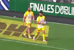Grégory Alldritt (wearing a headguard) and Hastoy (ball in hand) playing for Stade Rochelais La Rochelle against Saracens F.C. Saracens in 2023
