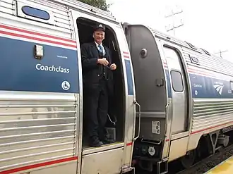 A conductor standing in the doorway of a train