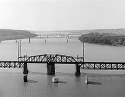 A truss swing bridge span in the center of a wide river