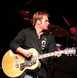 Andy Griggs, singing while playing an acoustic guitar