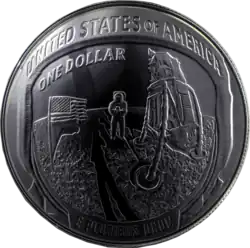 A coin with a scene from the moon landing engraved in it, as well as the words "United States", "One dollar", and the Latin phrase "E Pluribus Unum"