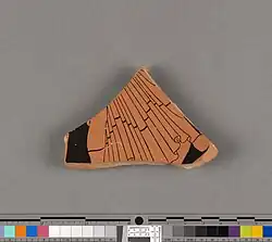Small pottery fragment, painted in red-figure: flowing, overlapping folds of fabric in motion can be seen.