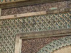 The Arabic inscription running along the top of the gate, with more darj wa ktaf and zellij decoration below