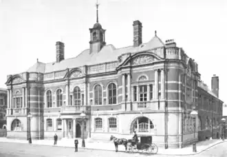 Black and white photo of a two-story stone and brick building