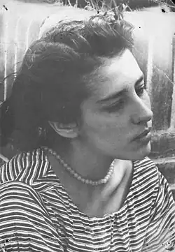 B&W portrait photo of a young woman wearing a striped shirt and pearls, her hair swept back from her face.