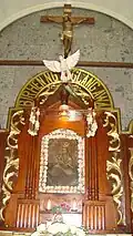 Closeup of the icon in its altar, showing its title and carved frame.