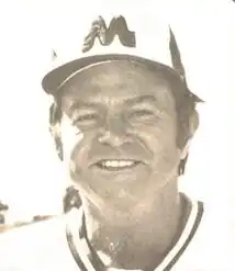 A black and white photograph of a man wearing a baseball uniform and cap with a "M".
