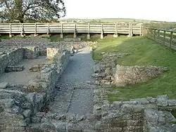 The ruins of a building. The remains of stone walls up to about 1-foot (0.30&nbsp;m) are all that remains.