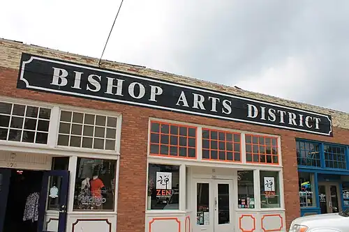 Old brick commercial building with signage "Bishop Arts District" above several of the shops (2012)