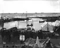 Boats and tents at the mouth of the Snake River in Nome, ca. 1900