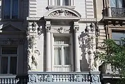 Detail of the façade, showing the ornate lampposts with putti