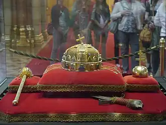 The real Holy Crown of Hungary, with the orb, sword of state and sceptre, on display at the Hungarian Parliament Building in Budapest; note the apostolic double cross on the orb