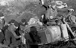a black and white photograph of a group of soldiers pushing a motorcycle combination up a hill[45]