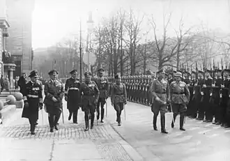 Werner von Blomberg inspects a parade in his honour on his birthday. Soldiers with Guns stand to attention.