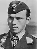 A portray of a man wearing a military uniform, side cap and neck order in shape of an Iron Cross.