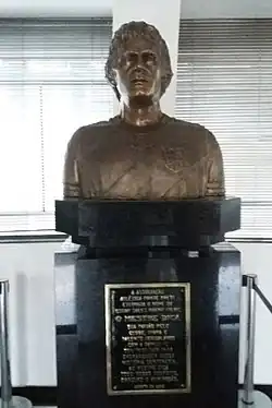 A bronze bust of Dicá with a plaque underneath it