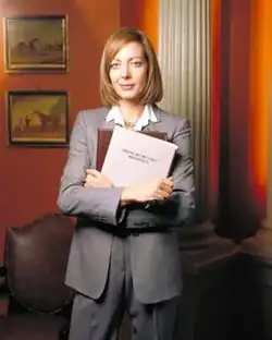 Allison Janney, pictured in costume as C. J. Cregg, for a promotional shoot
