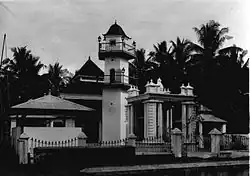 A black and white picture of a mosque with palm trees in the background