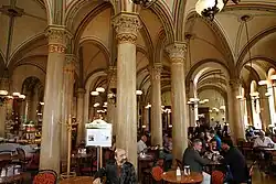 Cafe Central in Vienna interior near entrance with statue of Peter Altenberg