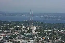 Three radio towers in the middle of midrise apartment buildings.