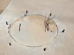 A close-up view of the first calibration target manhole, with cement cover and rebar handles. Around the cover protrude six equidistant pieces of rebar.