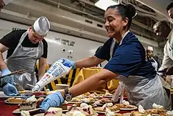 YNC Inez Cannon adds the topping to Thanksgiving dinner pie aboard USS Theodore Roosevelt (CVN-71).