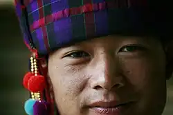 Chinese man in traditional hat of silk tartan with wool pompons, 2008
