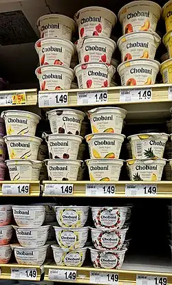 Grocery store shelf with dozens of single servicing yogurt containers.