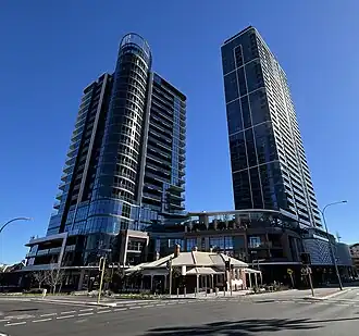 Two high rise apartment buildings viewed from a street intersection