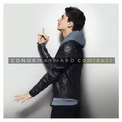 Maynard stands side-on to the camera against a white background. He wears a black leather jacket over a blue hoodie, and is pointing his index finger upwards. Across the centre of screen is the name "Conor Maynard", and the title "Contrast".