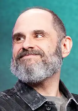 Craig Mazin smiling to the left