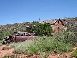 Old stone schoolhouse with abandoned vehicle
