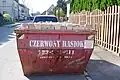A waste container with the inscription in Silesian Czerwony Hasiok (red trash can)